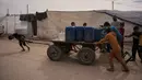 Mayoritas warga Palestina di Gaza masih sangat bergantung pada bantuan kemanusiaan yang masuk secara terbatas dan sering terhambat oleh kebijakan blokade. Tampak dalam foto, anak-anak Palestina mendorong gerobak yang berisi wadah plastik berisi air yang dikumpulkan dari pabrik desalinasi, Khan Younis, Jalur Gaza selatan, Jumat 6 Februari 2026. (AP Photo/Abdel Kareem Hana)