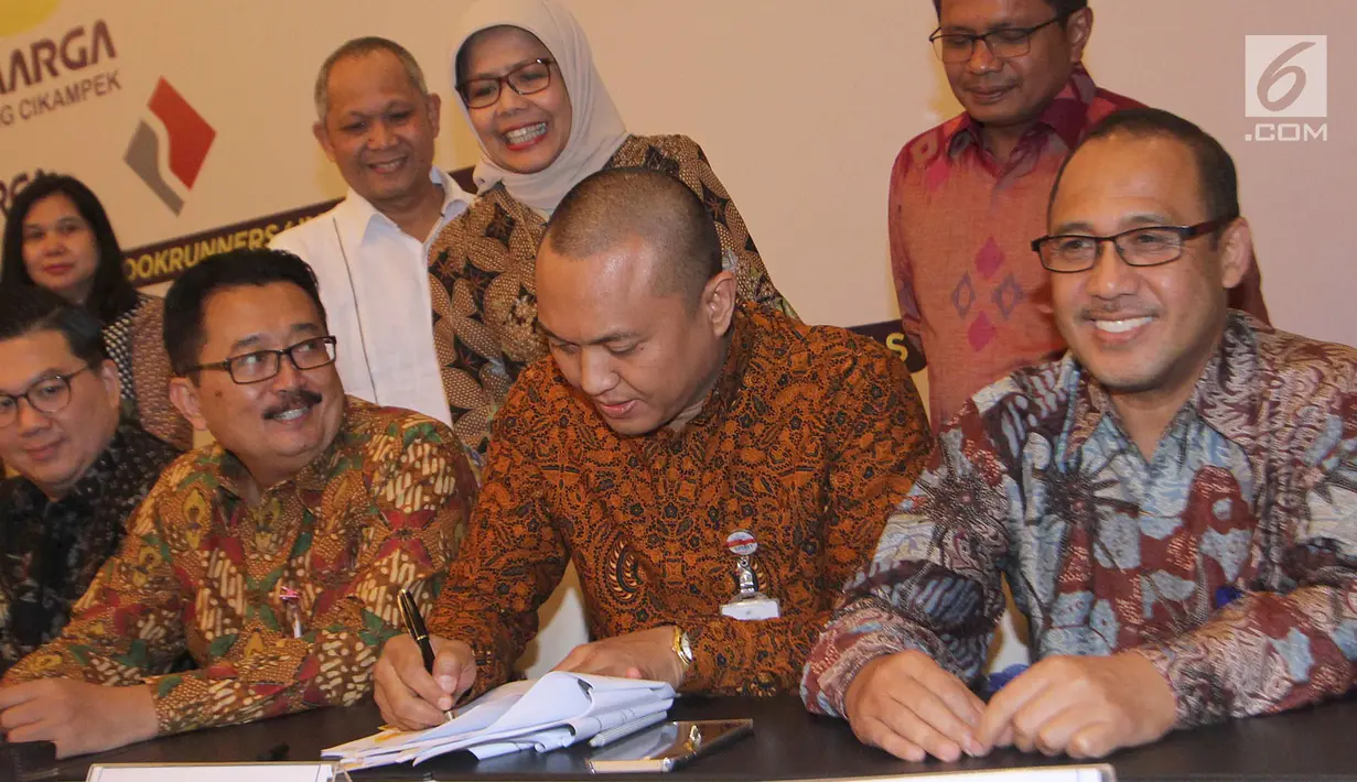 Dirut Jasa Marga Desi Arryani menyaksikan Pemimpin Divisi Korporasi & Komersial Bank BJB Dicky Syahbandinata menandatangani perjanjian kredit sindikasi Jasa Marga terkait pembangunan ruas Tol Cikampek II, Jakarta, Selasa (31/7). (Merdeka.com/Arie Basuki)