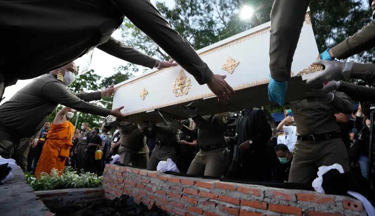 Polisi menyiapkan peti mati berisi korban serangan pusat penitipan anak untuk dikremasi di Kuil Wat Rat Samakee, Uthai Sawan, Thailand, Selasa (11/10/2022). Tragedi penembakan yang mayoritas korbannya adalah anak-anak tersebut telah terjadi pada Kamis 6 Oktober 2022. (AP Photo/Sakchai Lalit)