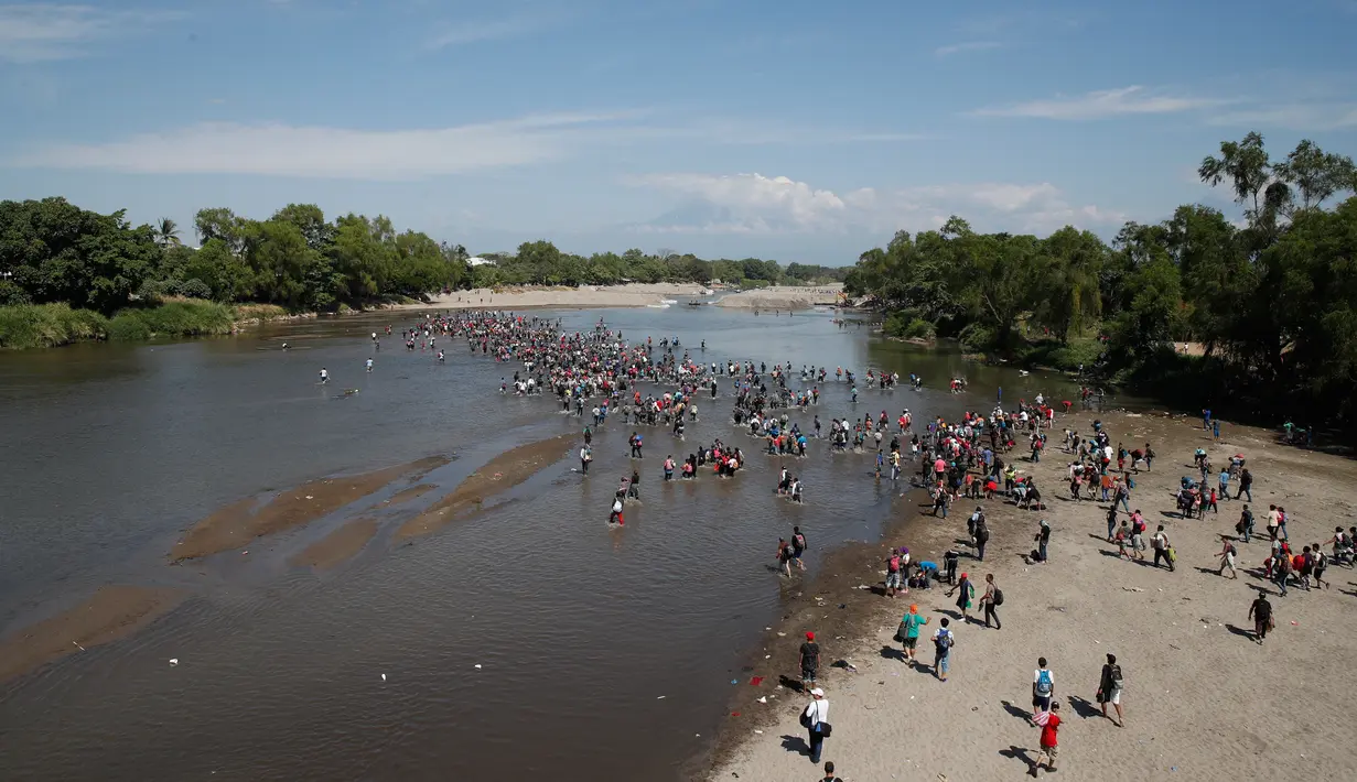 Migran Amerika Tengah menyeberangi Sungai Suchiate dengan berjalan kaki dari Guatemala ke Meksiko, Tecun Uman, Guatemala, Senin (20/1/2020). Lebih dari seribu migran Amerika Tengah yang terdampar di Guatemala berjalan massal untuk menuju Amerika Serikat. (AP Photo/Moises Castillo)