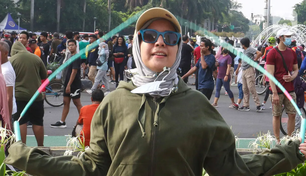 Aktris Tya Ariestya bermain lompat tali saat Car Free Day di kawasan bundaran Hotel Indonesia, Jakarta, Minggu (12/6/2022). Tya Ariestya tampil dengan sweater dan celana hijau serta kaca mata hitam. (Liputan6.com/Herman Zakharia)