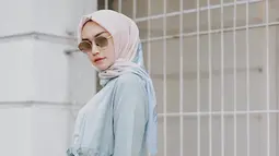 Tampil dengan blouse tosca dan hijab motif, gaya pemeran sinetron Dia Bukan Cinderella ini semakin elegan dengan kacamata berlensa gelap. Penampilannya terlihat santai namun berkelas. (Liputan6.com/IG/@melodyprima)