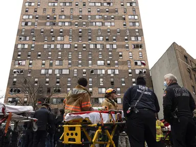 Petugas darurat bekerja di lokasi kebakaran gedung apartemen di Bronx, New York, Amerika Serikat, 9 Januari 2022. Sebanyak 19 orang tewas dalam kebakaran maut tersebut. (AP Photo/Yuki Iwamura)