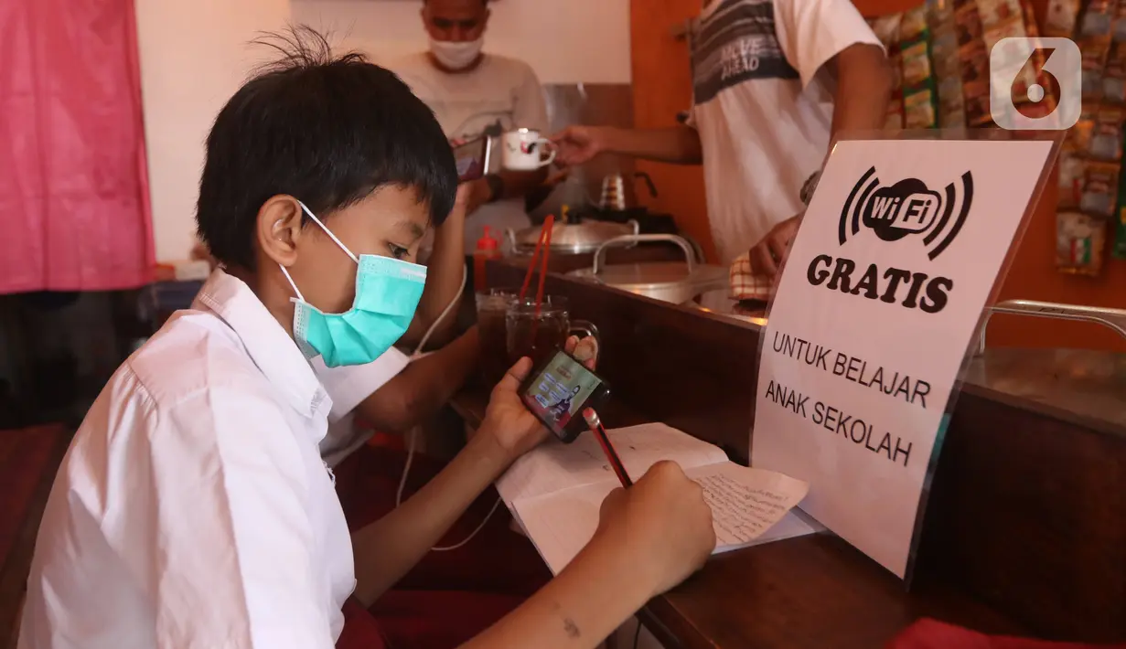 Seorang siswa sekolah dasar belajar dengan menggunakan wifi gratis yang disediakan oleh warkop Rizki, di Pondok Aren, Tangerang Selatan, Rabu (29/7/2020). Warung kopi tersebut menyediakan wifi gratis dan peminjaman laptop serta handphone. (Liputan6.com/Angga Yuniar)
