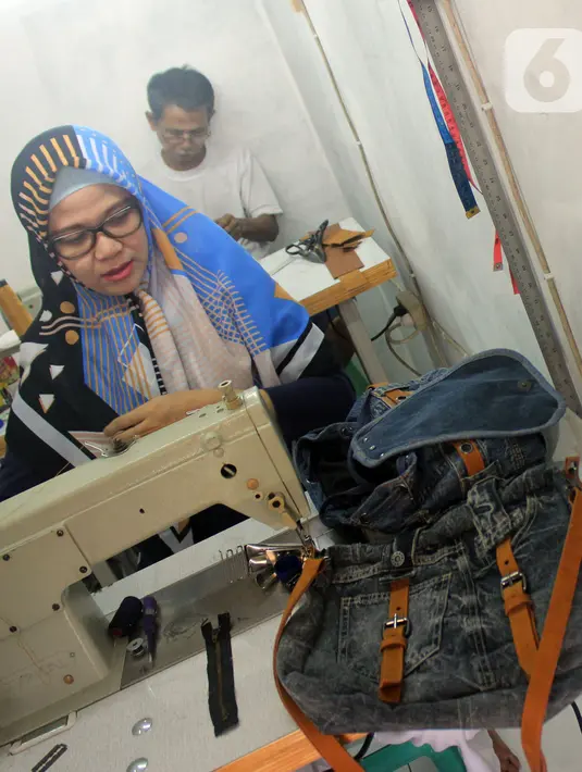 Perajin Risma Eljundi menyelesaikan pembuatan tas dari bahan celana jeans bekas di Legok, Tangerang, Banten, Senin (11/11/2019). Tas berbahan jeans itu dipasarkan ke kawasan Bandung serta pasar daring. (merdeka.com/Arie Basuki)