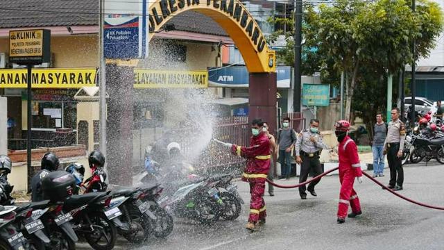 Petugas Pemadam Kebakaran Kota Pekanbaru menyemprotkan cairan disinfektan untuk mencegah penyebaran virus corona.