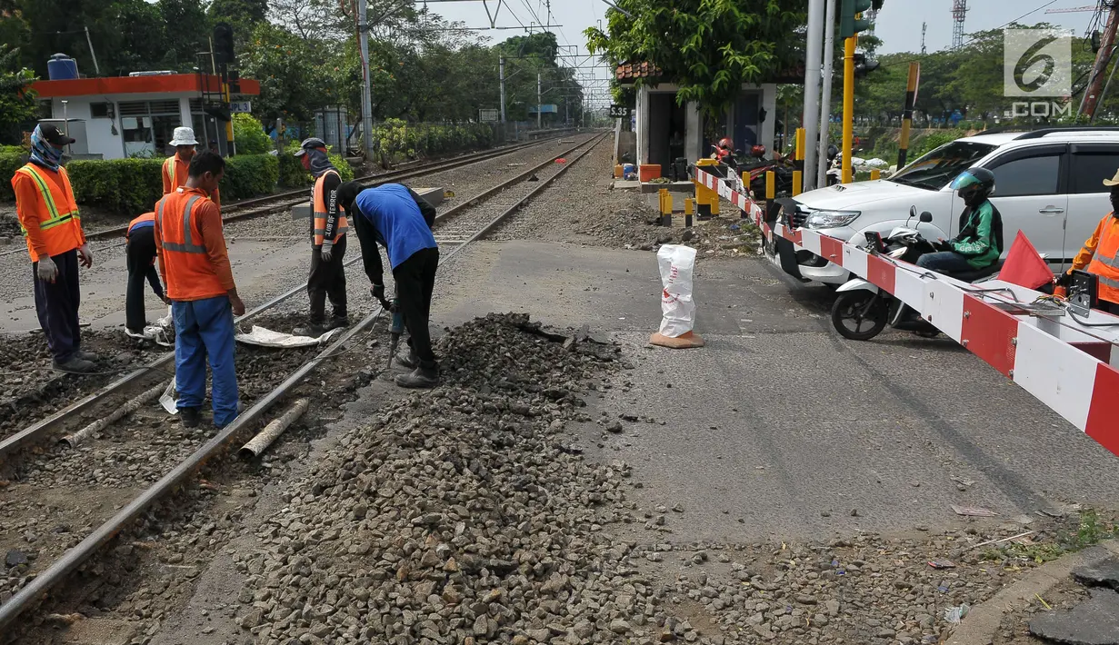 Pekerja membongkar aspal untuk melakukan perawatan rutin rel kereta api di Manggarai, Jakarta, Selasa (11/7). Perawatan dan pengecekan rutin rel kereta api itu guna menjamin keselamatan perjalanan kereta api. (Liputan6.com/Helmi Afandi)