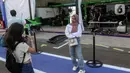 Beberapa penonton menyempatkan berfoto berlatar paddock Formula E. Balapan utama Jakarta E-Prix 2025 akan berlangsung pada Sabtu 21 Juni 2025 sore dan mengambil tajuk Sarinah Jakarta E-Prix 2025. (Liputan6.com/Herman Zakharia)
