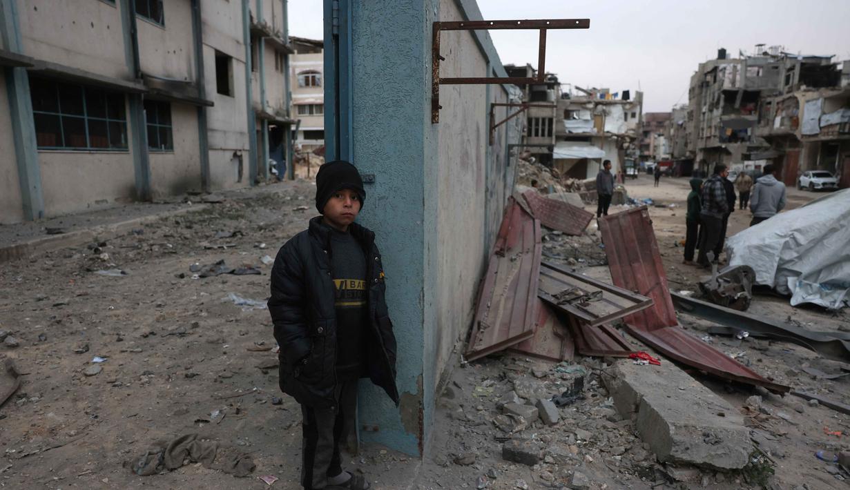 Sedikitnya 21 warga Palestina tewas, termasuk anak-anak dan seorang petugas medis. Tampak dalam foto, seorang pengungsi Palestina berdiri di samping tembok setelah pesawat Israel menargetkan sebuah rumah berlantai lima tadi malam, di Khan Yunis, Jalur Gaza selatan pada Kamis 6 Februari 2026. (Bashar Taleb/AFP)