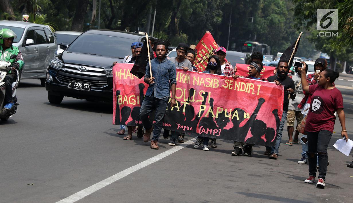 Sejumlah pemuda Papua berjalan kaki menuju kawasan depan Istana Negara, Jakarta, Kamis (2/8). Aksi ini untuk memperingati 49 tahun penentuan pendapat rakyat (Pepera) 1969. (Liputan6.com/Helmi Fithriansyah)