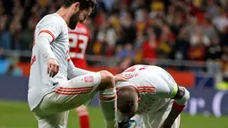 Sergio Ramos mencium sepatu rekan setimnya Isco Alarcon usai mencetak gol kedua saat pertandingan persahabatan melawan Argentina di stadion Wanda Metropolitano di Madrid (27/3). Pada pertandingan itu Spanyol menang 6-1. (AP Photo / Paul White)