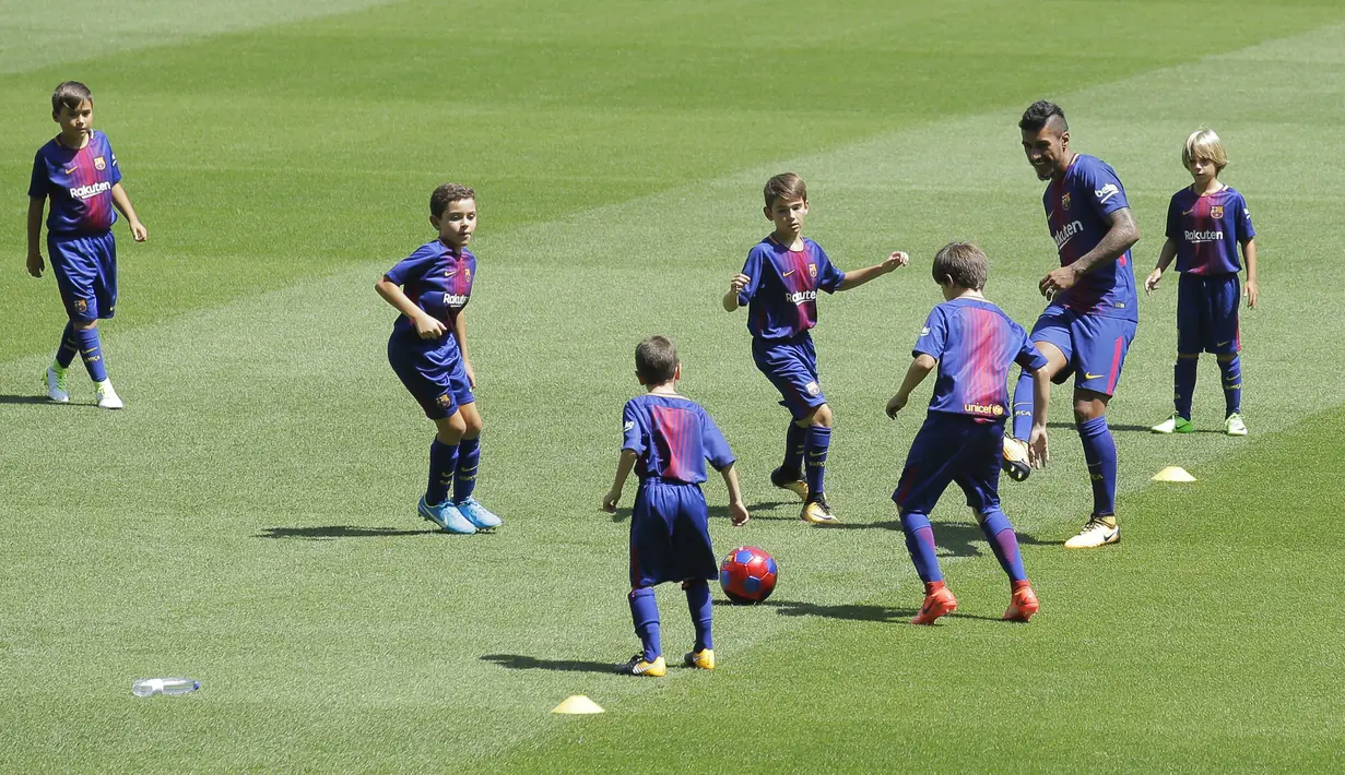Gelandang baru Barcelona, Paulinho, bermain bola bersama anak-anak saat diperkenalkan di Stadion Camp Nou, Kamis (17/7/2017). Pria asal Brasil ini resmi berseragam Barcelona setelah ditebus dari Guangzhou Evergrande. (AP/Manu Fernandez)