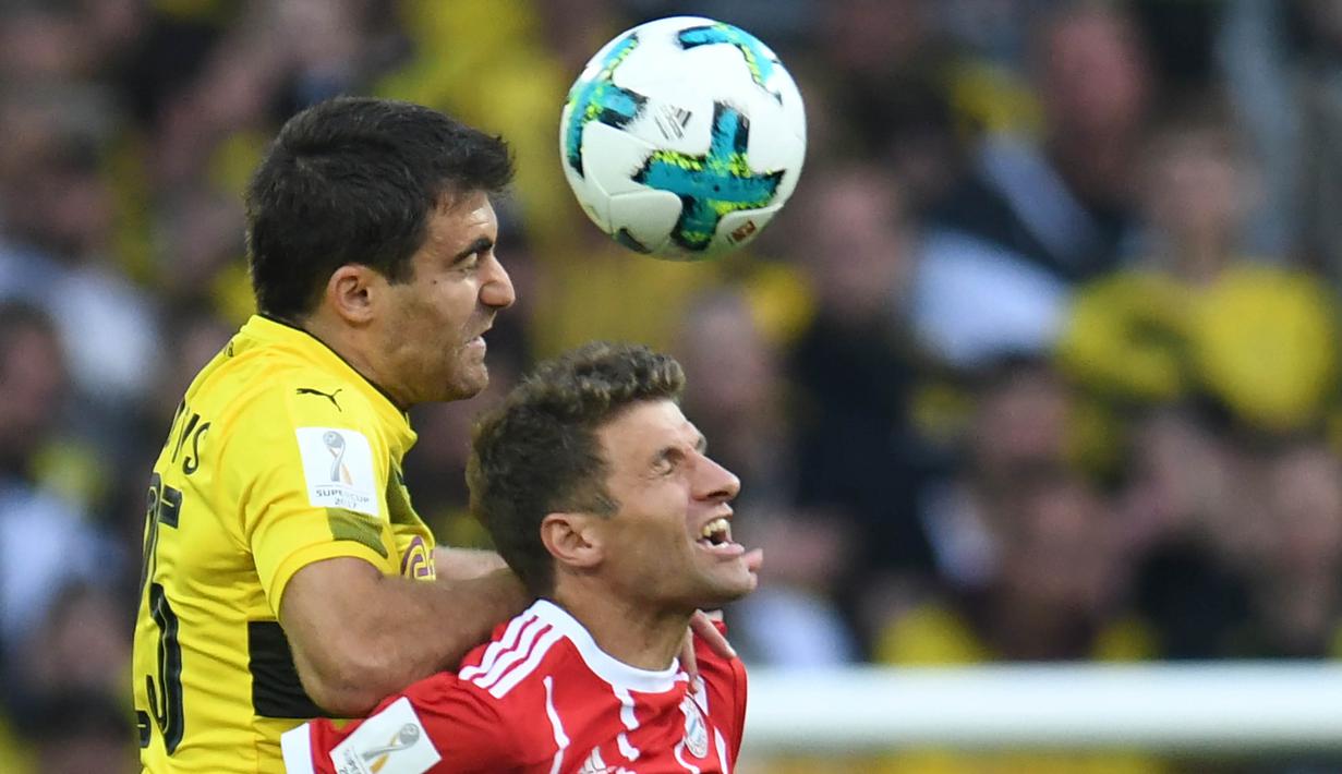 Bek Dortmund, Sokratis, duel udara dengan striker Bayern Munchen, Thomas Mueller, pada laga Piala Super Jerman di Stadion Signal Iduna Park, Dortmund, Sabtu (5/8/2017). Bayern Munchen menang adu penalti 5-4 atas Dortmund. (AFP/Patrik Stollarz)