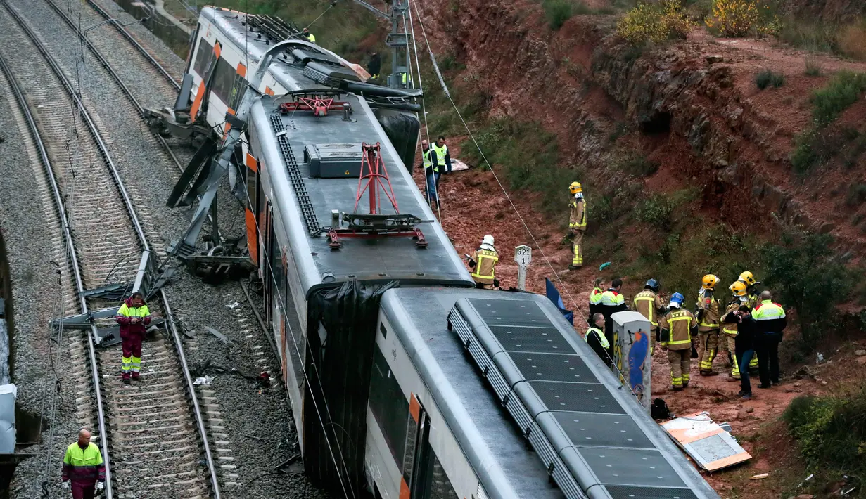 Regu penyelamat mengevakuasi penumpang dari dalam kereta komuter yang tergelincir dari rel di Vacarisses, Barcelona, Selasa (20/11). Sedikitnya 1 orang tewas akibat longsor yang menerjang sebuah kereta hingga menyebabkannya keluar jalur. (Pau Barrena/AFP)