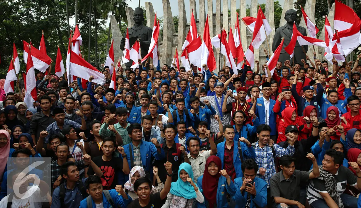 Mahasiswa mengibarkan bendera merah putih berfoto bersama di depan Patung Soekarno - Hatta di Tugu Proklamasi, Jakarta, Kamis (3/11). Para mahasiswa ini mengikuti acara apel Kebangsaan Mahasiswa Indonesia. (Liputan6.com/Johan Tallo)