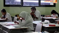 Para siswa SMA 112 Jakarta terlihat serius mengerjakan soal-soal ujian nasional pada Senin (14/4/2014). (Liputan6.com/Johan Tallo)