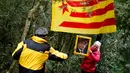 Seorang wanita memegang foto presiden terguling Catalonia, Carles Puigdemont saat mereka membawa ke Gunung Montserrat, Spanyol (28/4). Monserrat sendiri merupakan salah satu tempat ziarah bagi‎ umat Katolik yang paling dikenal di Eropa .(AFP/Pau Barrena)