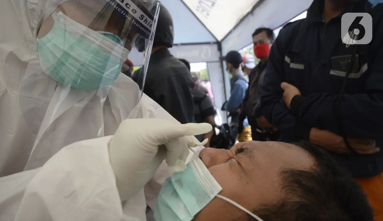 Petugas medis melakukan rapid test pada pengendara yang terjaring razia masker di Jalan Panjang, Kedoya, Jakarta Barat, Senin (2812/2020). Pengendara yang tidak mengenakan masker langsung menjalani rapid test antigen gratis untuk mencegah penularan COVID-19. (merdeka.com/Dwi Narwoko)