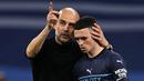 Pelatih Manchester City, Pep Guardiola (kiri) menenangkan Phil Foden setelah pertandingan semi final leg kedua melawan Real Madrid yang berlangsung di Santiago Bernabeu, (4/5/2022). Phil Foden yang kini dalam masa keemasannya tak mungkin bergabung dengan The Citizen jika harus turun kasta. Meskipun Foden merupakan didikan akademi Manchester City dan masih terikat kontrak hingga 2027 bukan tidak mungkin Foden akan angkat kaki di bursa transfer. (AFP/Paul Ellis)