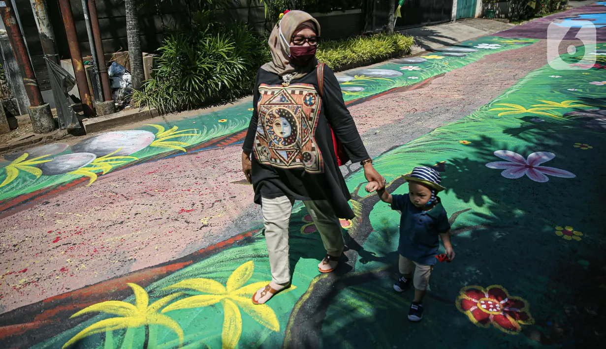 Warga melintas di atas jalan yang telah dilukis mural di Jalan Keuangan, Cilandak, Jakarta, Rabu (26/8/2020). Mural di sepanjang jalan Keuangan menuju museum Basoeki Abdullah itu bertujuan memperindah wilayah tersebut serta sebagai ajang promosi museum. (Liputan6.com/Faizal Fanani)