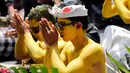 Para pemuda berdoa selama  ritual Hindu yang disebut "Grebeg" di Desa Tegallalang, Bali, Rabu (30/1). Dalam ritual dua tahunan ini, para pemuda berkeliling kampung dengan riasan tubuh warna-warni untuk menangkal Roh jahat. (AP/Firdia Lisnawati)