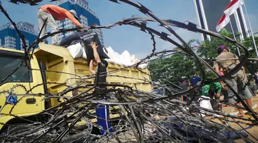 Petugas tampak mengangkut tanaman yang rusak di Taman Silang Monas, Jakarta, Jumat (22/8/14). (Liputan6.com/Faizal Fanani)