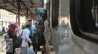 Pemudik memasuki kereta api di Stasiun Senen, Jakarta, Selasa (7/7/2015). Para pemudik mengaku sengaja mudik lebih awal untuk menghindari puncak arus mudik yang diperkirakan akan terjadi pada H-5 Lebaran. (Liputan6.com/Herman Zakharia)
