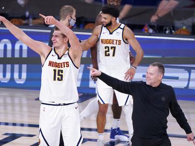Pebasket Denver Nuggets, Nikola Jokic dan pelatih  Michael Malone, usai menaklukkan Los Angeles Clippers pada gim ketujuh semifinal playoff NBA di Lake Buena Vista, Selasa (15/9/2020).  Nuggets menang dengan skor 104-89. (AP/Mark J. Terrill)