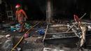 Petugas Damkar melintas di dekat bangunan yang terbakar di Pasar Senen, Jakarta, Kamis (19/1). Penyebab kebakaran masih dalam tahap penyelidikan. (Liputan6.com/Gempur M Surya)