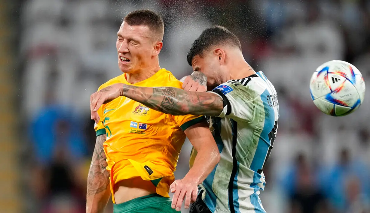 Pemain Australia Mitchell Duke dan berebut bola dengan pemain Argentina Nicolas Otamendi pada pertandingan sepak bola babak 16 besar Piala Dunia 2022 di Stadion Ahmad Bin Ali, Doha, Qatar, 3 Desember 2022. Argentina berhasil melaju ke babak perempat final Piala Dunia 2022 usai menyingkirkan Australia dengan skor 2-1. (AP Photo/Lee Jin-man)