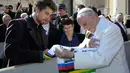 Paus Fransiskus melihat jersey yang diberikan oleh Peter Sagan pada akhir audiensi mingguan di Vatikan (24/1). Peter Sagan merupakan pebalap pertama yang memenangkan gelar juara dunia elit putra tiga kali berturut-turut. (AFP/HO/Osservatore Romano)