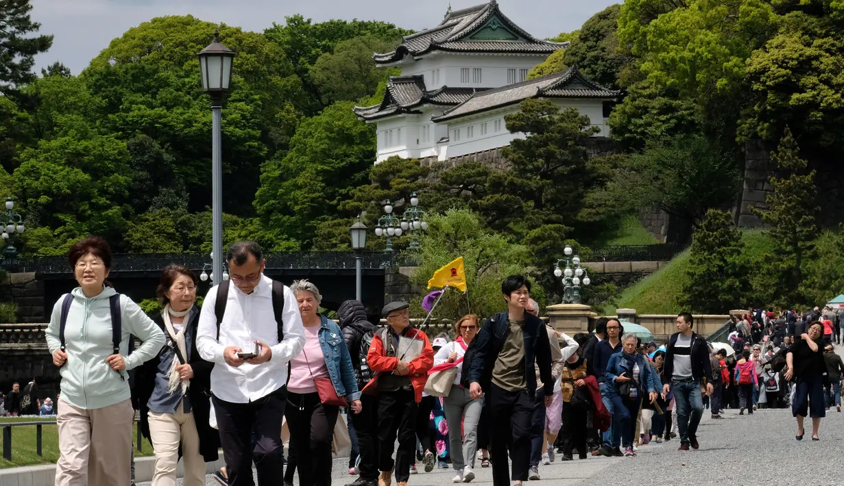 Wisatawan mengunjungi di area Taman Istana Kekaisaran di Tokyo, Jepang (29/4/2019). Kaisar Jepang Akihito akan turun dari Tahta Krisan pada 30 April 2019 yang pertama dalam keluarga kekaisaran dan tertua di dunia selama dua abad, atau selama 30 tahun masa pemerintahan. (Kazuhiro NOGI / AFP)
