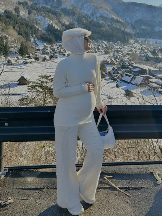 <p>Berlibur ke Jepang, Dinda Hauw tampil serba putih dengan atasan sweater yang serasi dengan kerudung dan celana cutbray. (@dindahw)</p>