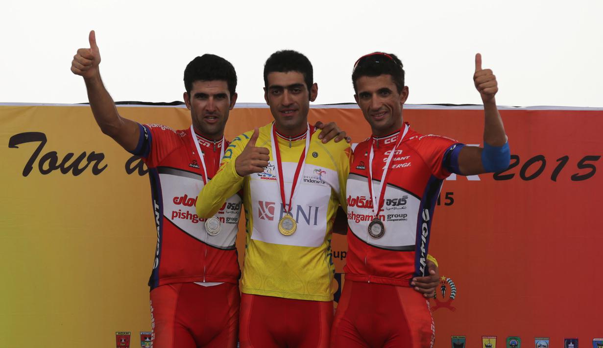 Tiga pebalap teratas klasifikasi umum (kiri ke kanan), peringkat 2 Amir Zargari, pemegang kaus kuning Arvin Moazemi Goudarzi, dan peringkat 3 Hossein Askari di podium Tour de Singkarak 2015 di Pantai Padang, Minggu (11/10/2015). (Bola.com/Arief Bagus)