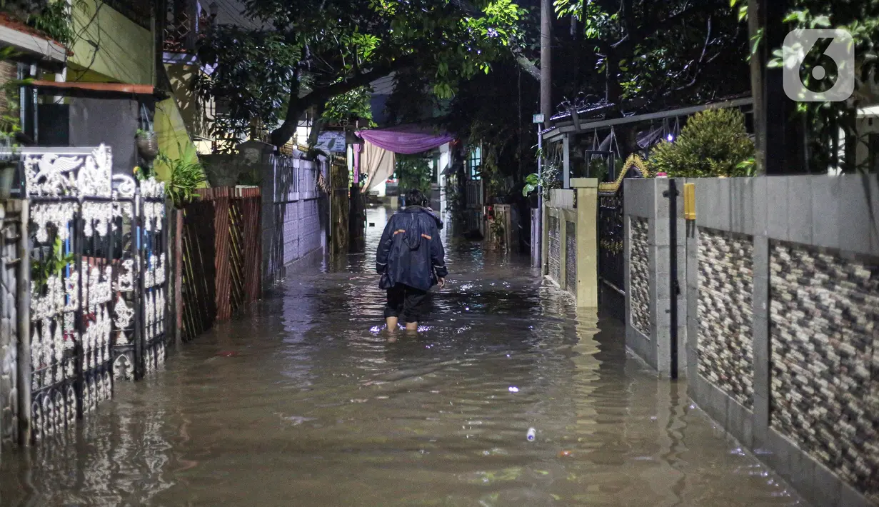 Warga berjalan menerjang banjir karena hujan di Jalan Shofa Marwah, Jakarta, Jumat (4/11/2022). Berdasarkan laporan Badan Penanggulangan Bencana Daerah (BPBD) DKI Jakarta yang diperbaharui pada pukul 18.00 WIB, terdapat 4 RT yang terendam banjir dengan ketinggian maksimal mencapai 50 Cm. (Liputan6.com/Faizal Fanani)