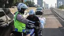 Petugas kepolisian memberhentikan pengemudi sepeda motor yang melintasi JLNT Kampung Melayu-Tanah Abang, Jakarta, Selasa (25/7). Polisi terus merazia kendaraan roda dua yang melanggar rambu larangan melintas di JLNT tersebut. (Liputan6.com/Faizal Fanani)