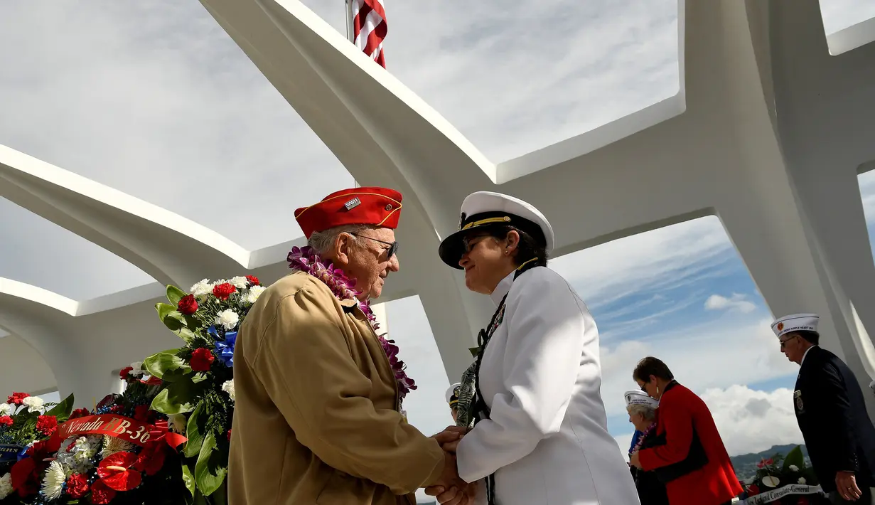 Veteran yang selamat dari bom Pearl Harbor, Paul Hilliard bersalaman dengan Admiral Chaplain, Margaret Kibben di atas kapal USS Arizona memorial saat upacara peringatan 75 tahun pengeboman Pearl Harbor di Honolulu, Hawaii (7/12). (Reuters/Hugh Gentry)