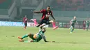 Pemain Persipura Jayapura, Tinus Pae melompat menghindari sapuan pemain PS TNI, Ganjar pada laga Torabika SC 2016 di Stadion Pakansari, Bogor, Minggu (19/6/2016). (Bola.com/Nicklas Hanoatubun)