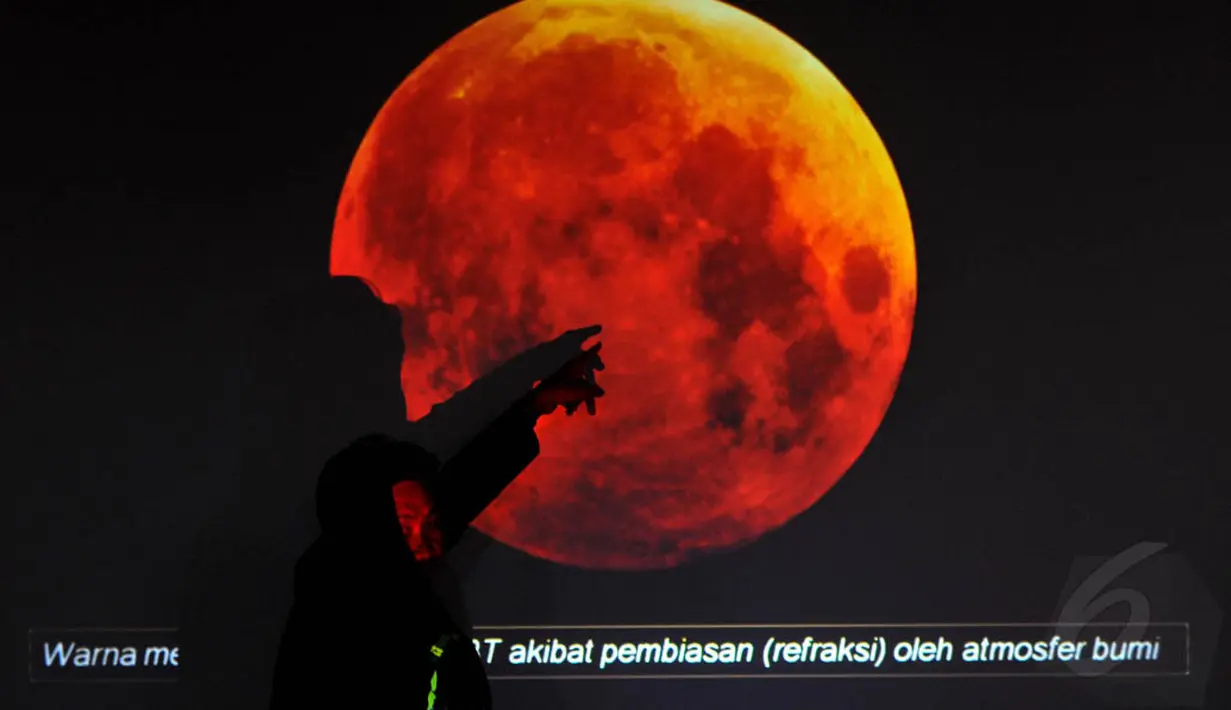 Seorang petugas menerangkan gambaran proses gerhana bulan total di Planetarium Taman Ismail Marzuki, Jakarta, (8/10/14).(Liputan6.com/Johan Tallo) 