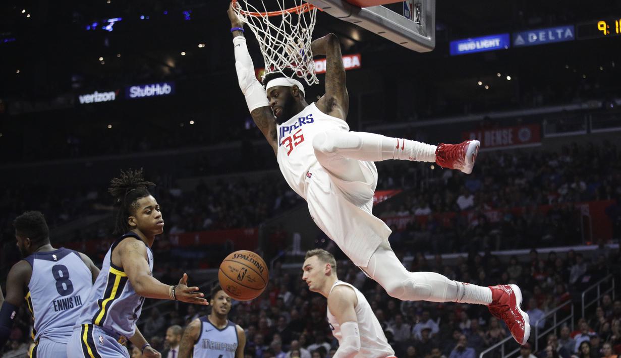 Pemain L. A. Clippers, Willie Reed bergelantungan pada ring usai mencetak poin saat melawan Memphis Grizzlies dalam laga NBA basketball game, di Staples Center, Los Angeles, (2/1/2018). Clippers menang 113-105. (AP/Jae C. Hong)