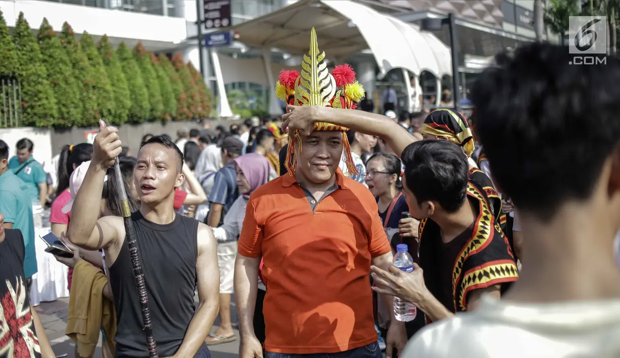 Warga berfoto dengan para peserta parade seni budaya Kepulauan Nias saat Car Free Day di Kawasan Jalan Sudirman, Jakarta, Minggu (4/3). (Liputan6.com/Faizal Fanani)