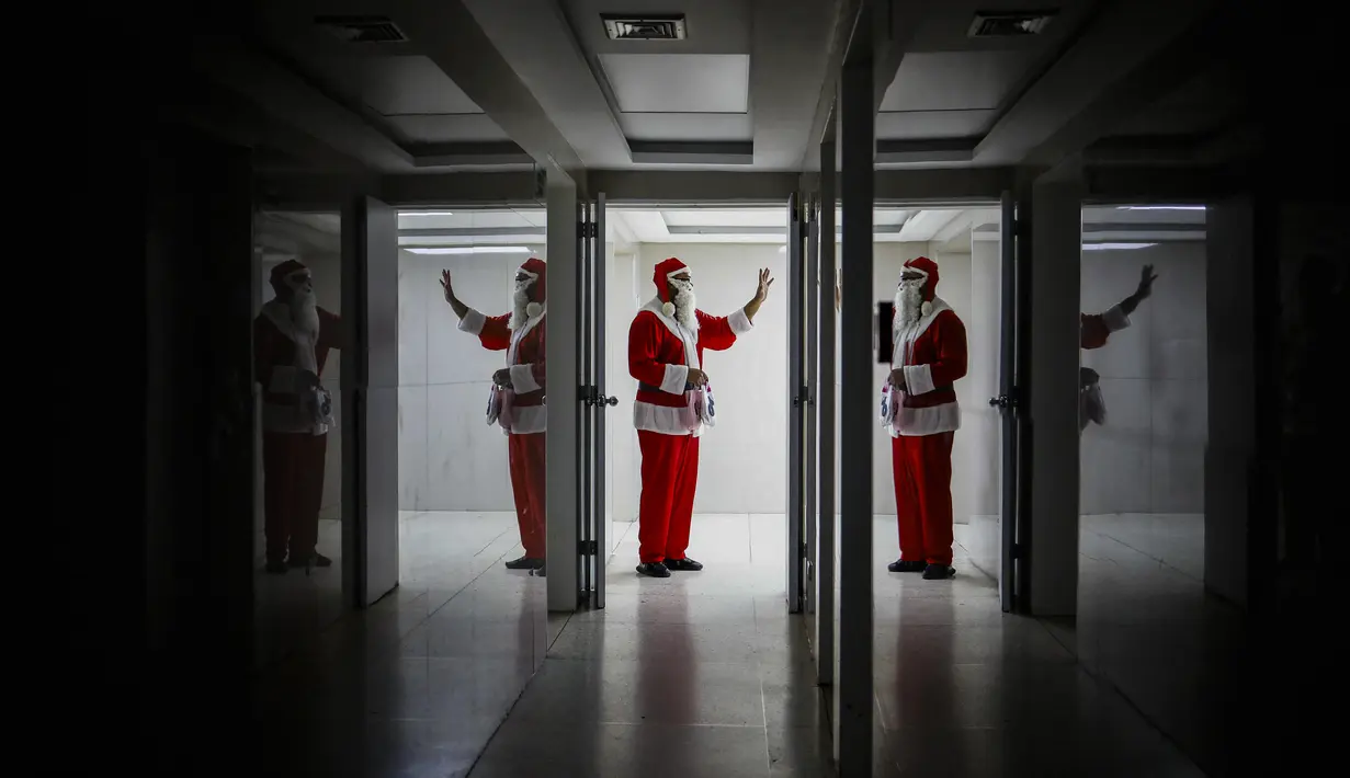 Seorang pria berpakaian seperti Sinterklas melambai di ruang gawat darurat sebuah rumah sakit di lingkungan El Cementerio di Caracas, Venezuela pada 25 Desember 2023. (Pedro Rances Mattey / AFP)