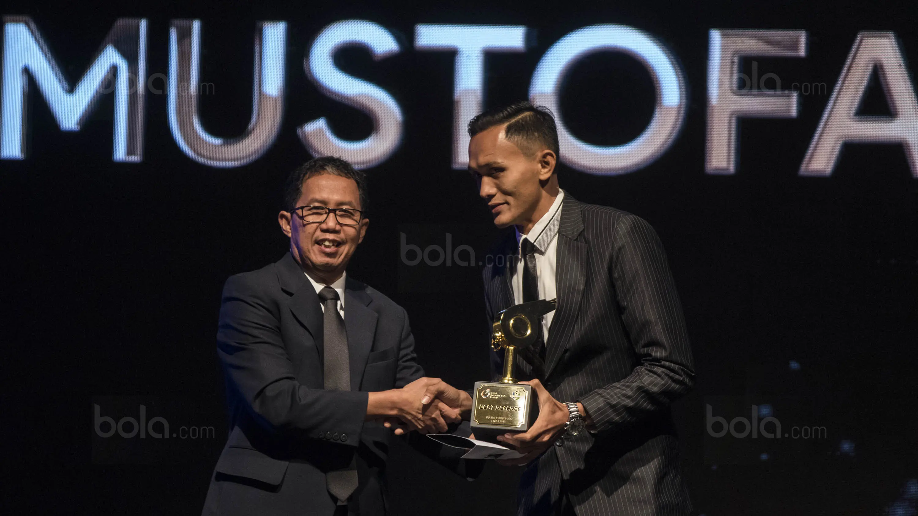 Mustofa Umarella menerima penghargaan wasit terbaik di Hotel Mulia, Jakarta, Jumat (22/12/2017). Malam Penghargaan Liga 1 memberi apresiasi kepada sejumlah tokoh sepak bola. (Bola.com/Vitalis Yogi Trisna)