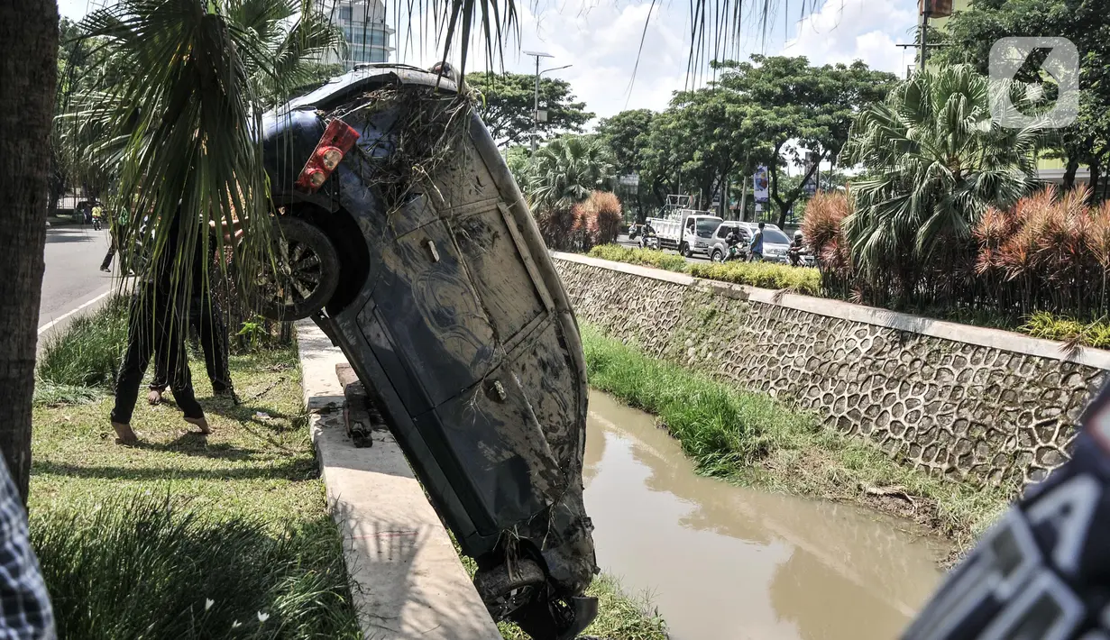 Petugas Dinas Perhubungan Kota Bekasi saat evakuasi mobil yang terperosok ke kali di Harapan Indah, Bekasi, Jawa Barat, Rabu (16/2/2022). Beruntung tidak ada korban jiwa dalam kejadian tersebut, namun mobil mengalami rusak parah. (merdeka.com/Iqbal S. Nugroho)