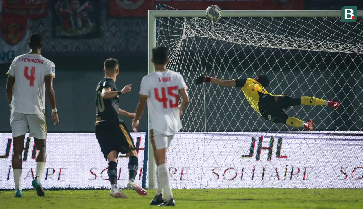 <p>Kiper PSM Makassar, M. Reza Arya Pratama berusaha menghalau bola hasil tendangan pemain Dewa United FC, Majed Osman Sobhi (kedua dari kiri) saat laga pekan ke-10 BRI Liga 1 2022/2023 antara Dewa United FC melawan PSM Makassar di Stadion Indomilk Arena, Tangerang, Kamis (15/9/2022). (Bola.com/Bagaskara Lazuardi)</p>