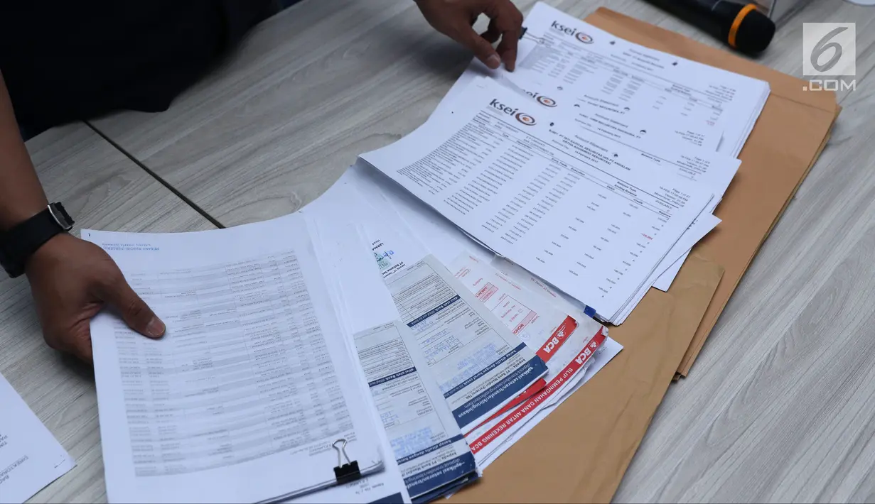 Petugas Tipideksus Bareskrim Polri membeberkan barang bukti penipuan dan penggelapan saham pasar modal saat rilis di Jakarta, Rabu (17/10). Bareskrim menangkap satu tersangka penipuan dan penggelapan saham pasar modal. (Liputan6.com/Helmi Fithriansyah)