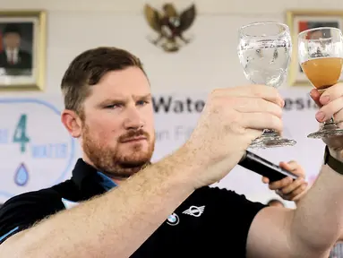 Field Director Waves for Water, Rob Mcqueen menunjukkan dua gelas air kotor dan air hasil filter Care4Water di RPTRA Krendang, Tambora, Jakarta Barat, Minggu (28/4/2019). Care4Water Indonesia membangun 5 tangki dengan 30 filter air di sekitar area RPTRA Krendang. (Liputan6.com/Ismail)