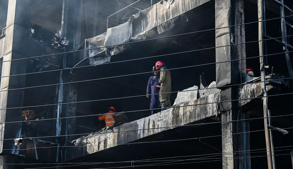 <p>Petugas pemadam kebakaran memeriksa sebuah gedung komersial sehari setelah kebakaran terjadi di New Delhi, India, Sabtu (14/5/2022). Kebakaran yang melanda gedung perkantoran empat lantai di Delhi, pada Jumat 13 Mei 2022, menewaskan sedikitnya 27 orang dan melukai sedikitnya 12 orang, kata layanan darurat. (Sajjad HUSSAIN / AFP)</p>