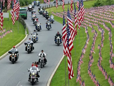 Sejumlah pengendara motor melintas di Pemakaman Nasional Indiantown untuk memperingati Hari Pahlawan di AS (27/5). Hari Pahlawan atau Hari Memorial ini diperingati setiap tahunnya pada Senin terakhir bulan Mei. (AP Photo/Michael Rubinkam)