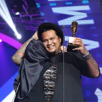 Di atas panggung, menerima piala kemenangannya itu Virgoun mengajak sang istri, Innara yang kini telah berhijab. Tampak keduanya berpelukan di atas panggung megah tersebut. (Bambang E.Ros/Bintang.com)